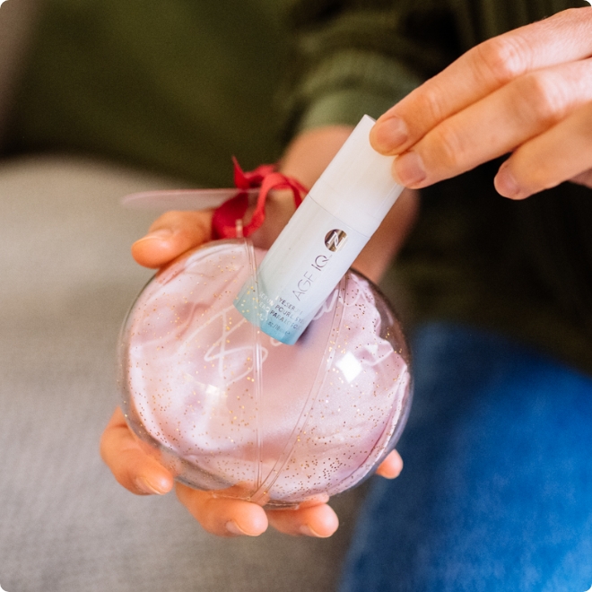 Woman holding Neora’s hottest holiday must-have, the All Eyes on You Set, which includes Age IQ® Eye Serum and FREE Eye Mask.